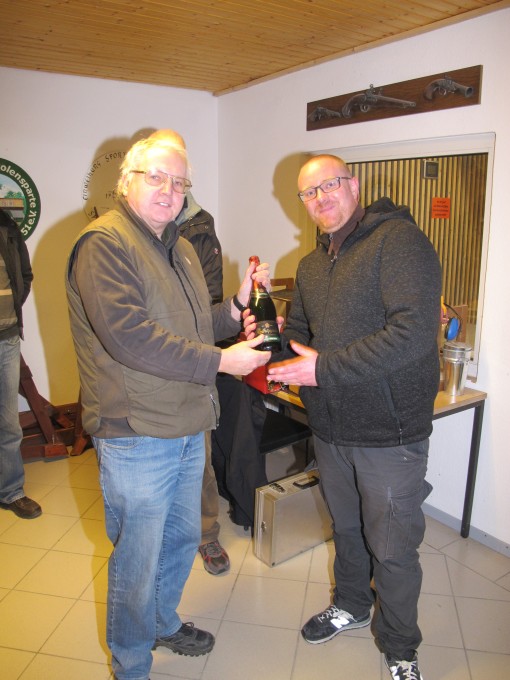 Trostspender Leif Zurek bekommt eine Flasche Sekt überreicht